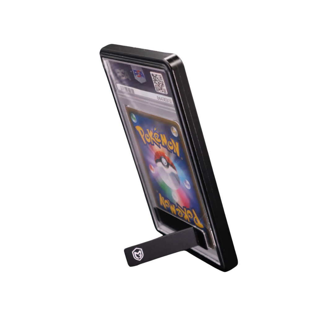 A black protective standing display graded card guard holding a graded trading pokemon onepiece sports cards and slabs, with an in-built kick stand 